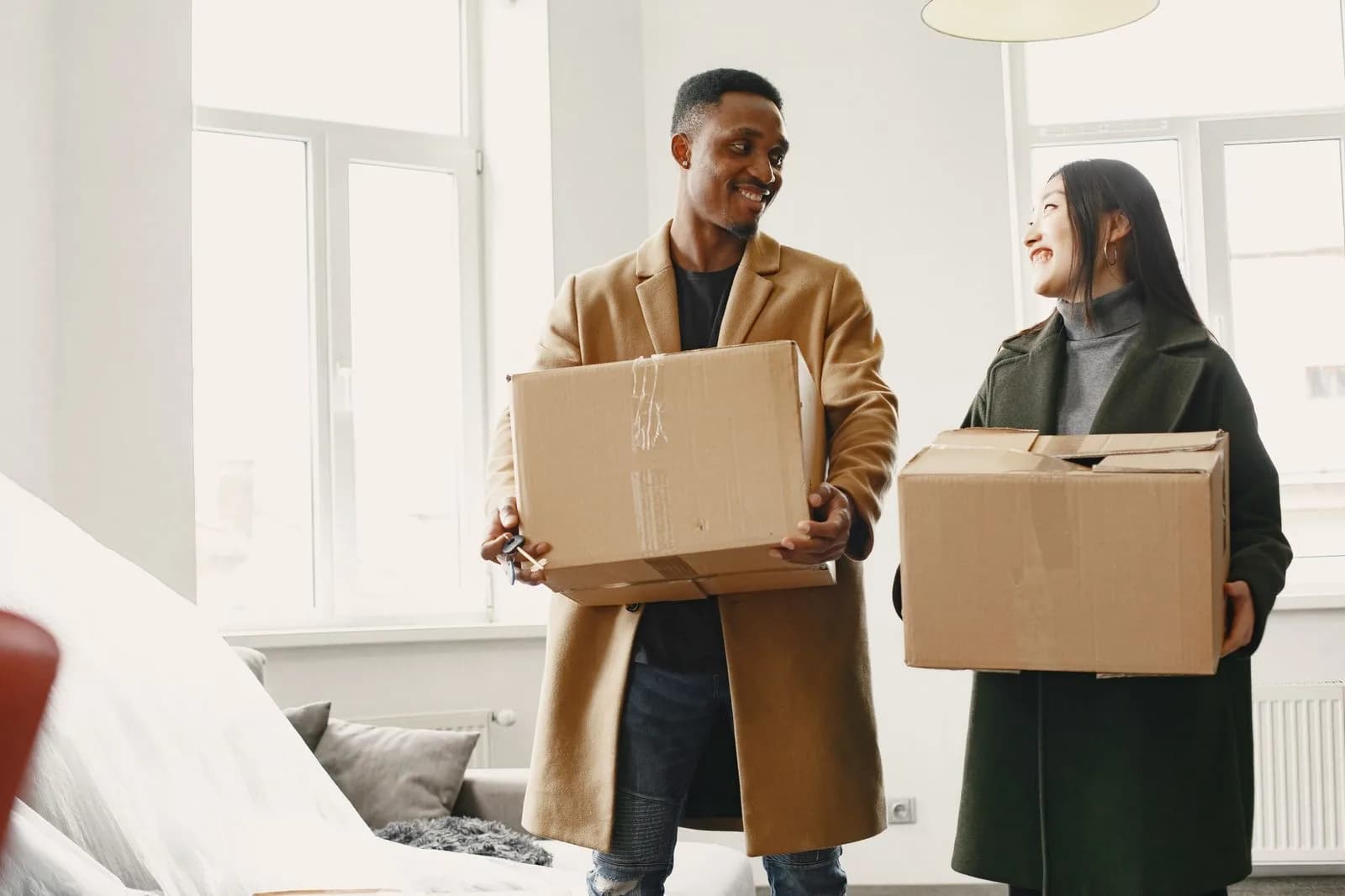 Un couple souriant emménage dans son nouveau logement